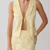 Tessa broderie mouwloze top met strik aan de voorkant – Lemon Tessa broderie mouwloze top met strik aan de voorkant – Lemon
